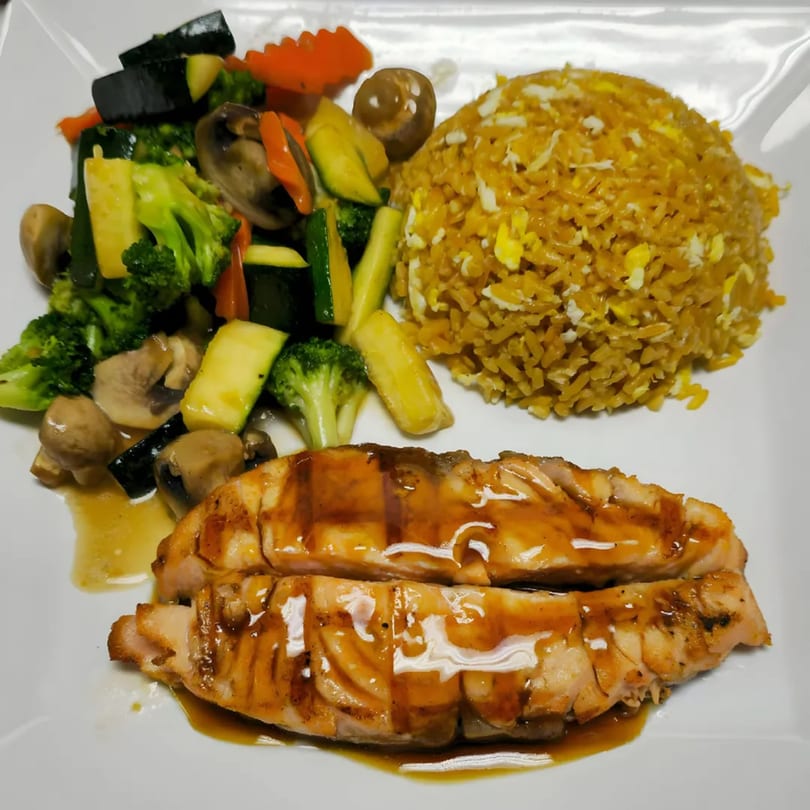 KOTO Asian Bistro's salmon teriyaki with fried rice and mixed vegetables on a white plate.
